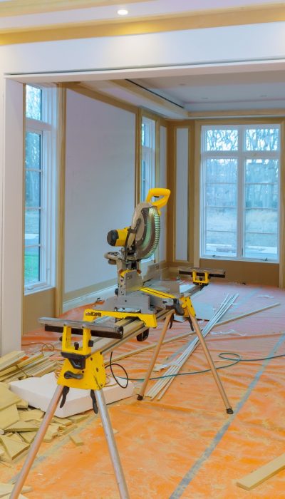 Construction remodeling home with close up of circular saw cutting wood trim molding